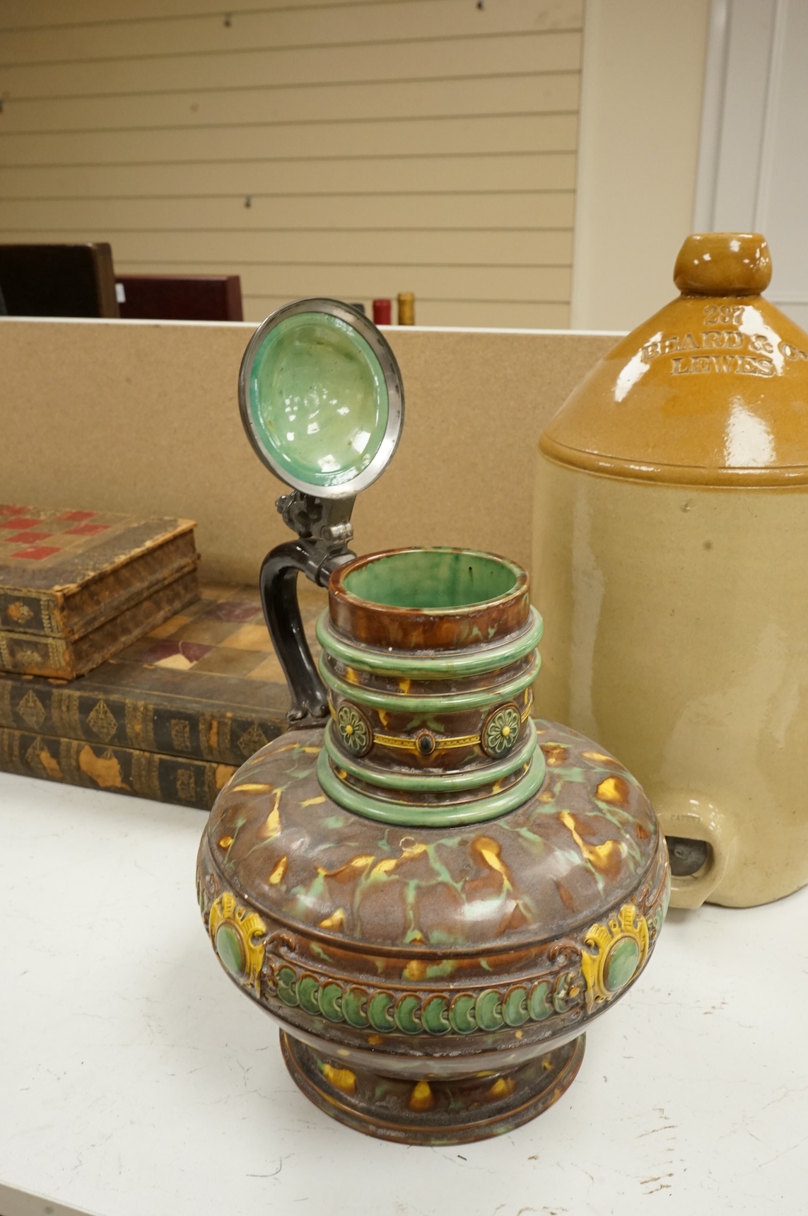 A German earthenware flagon, 32cm tall, together with a Beard & Co of Lewes stoneware liqueur flask